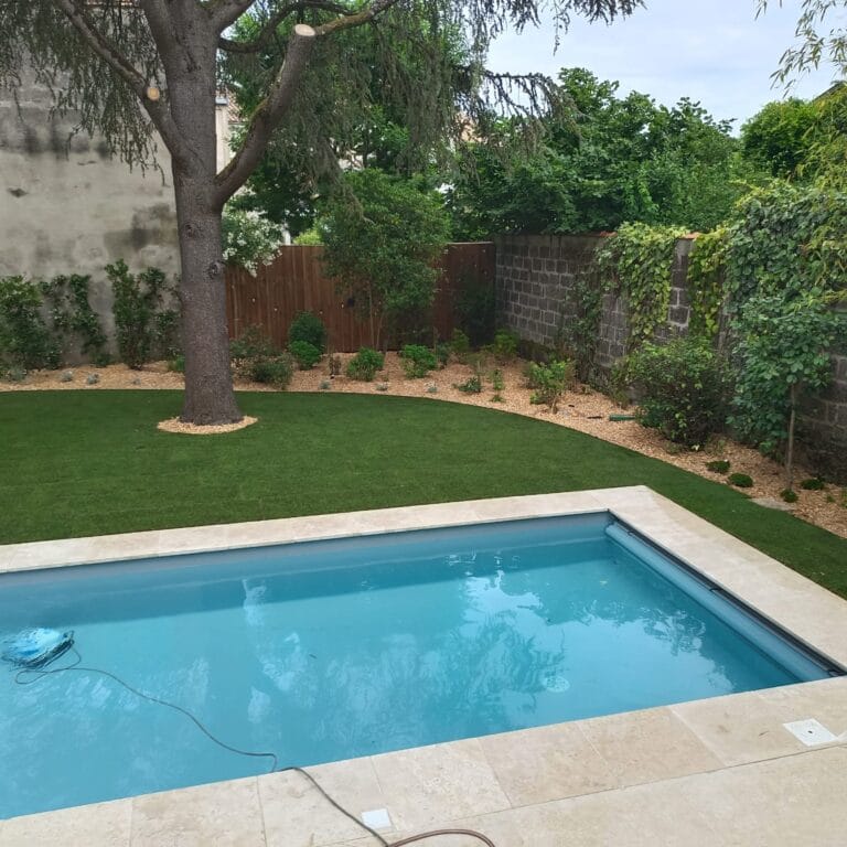 Pelouse et massif planté au pied d’un arbre, le long d’une piscine