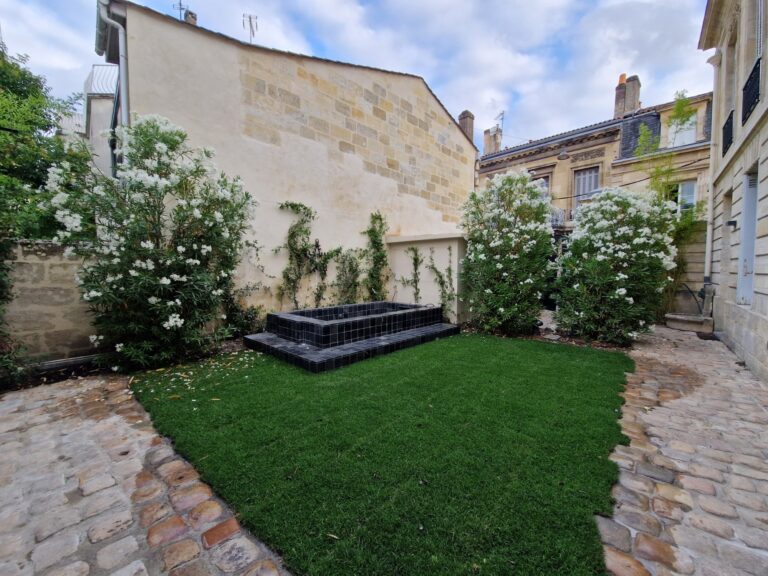 Cour bordelaise plantée de lauriers-roses le long des murs en pierre