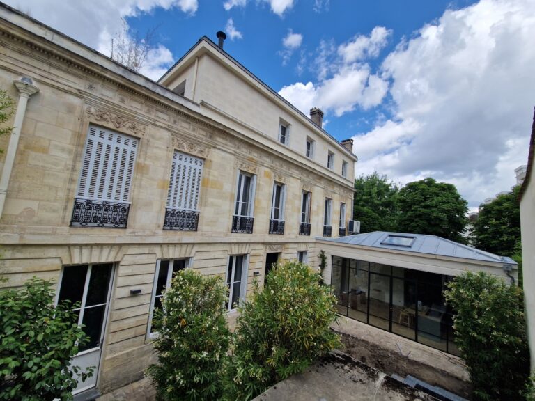 Façade en pierre de la maison bordelaise et sa véranda vitrée après travaux
