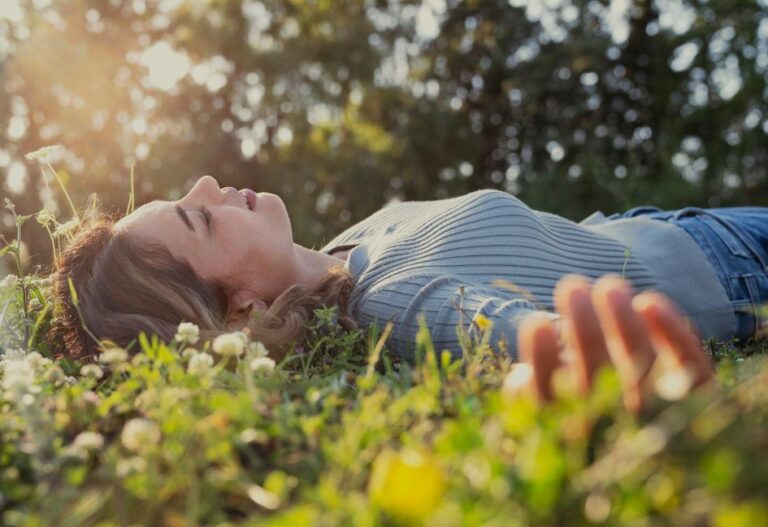 Personne allongée dans une prairie fleurie au soleil