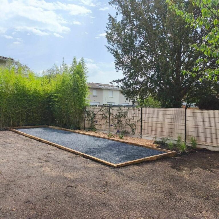 Terrain de pétanque terminé, gravillon gris et bordures en bois, près de Bordeaux