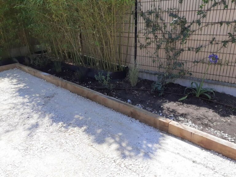 Traverses en chêne et fondation en calcaire compacté d'un terrain de pétanque